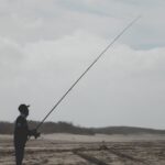 Hombre pescando con caña en río