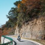 Motociclista recorriendo una espectacular carretera de montaña en otoño