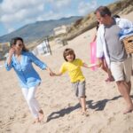 Familia caminando por la playa en un día soleado