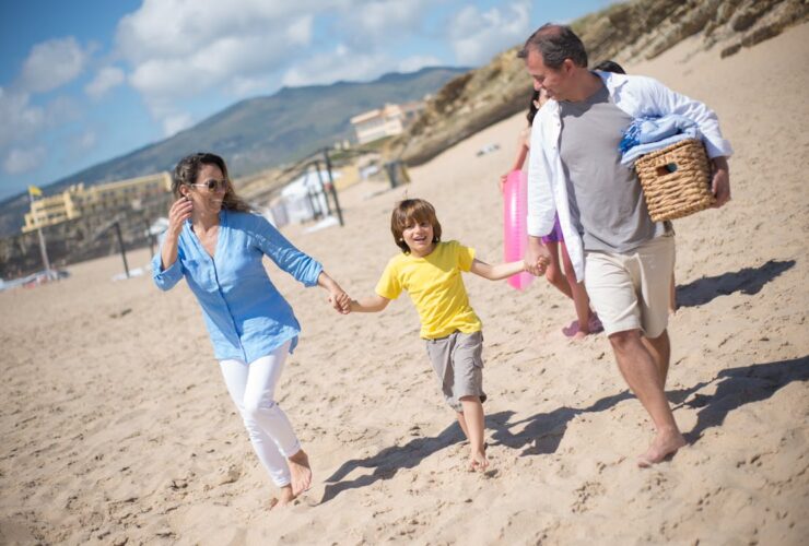 Familia caminando por la playa en un día soleado